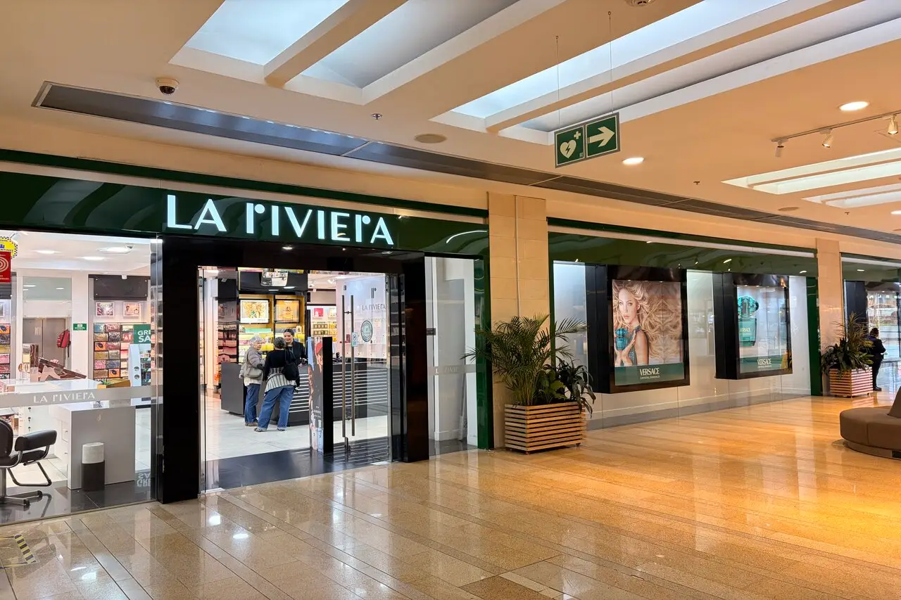 La Riviera storefront in a mall, glass doors open as customers browse cosmetics inside the store.