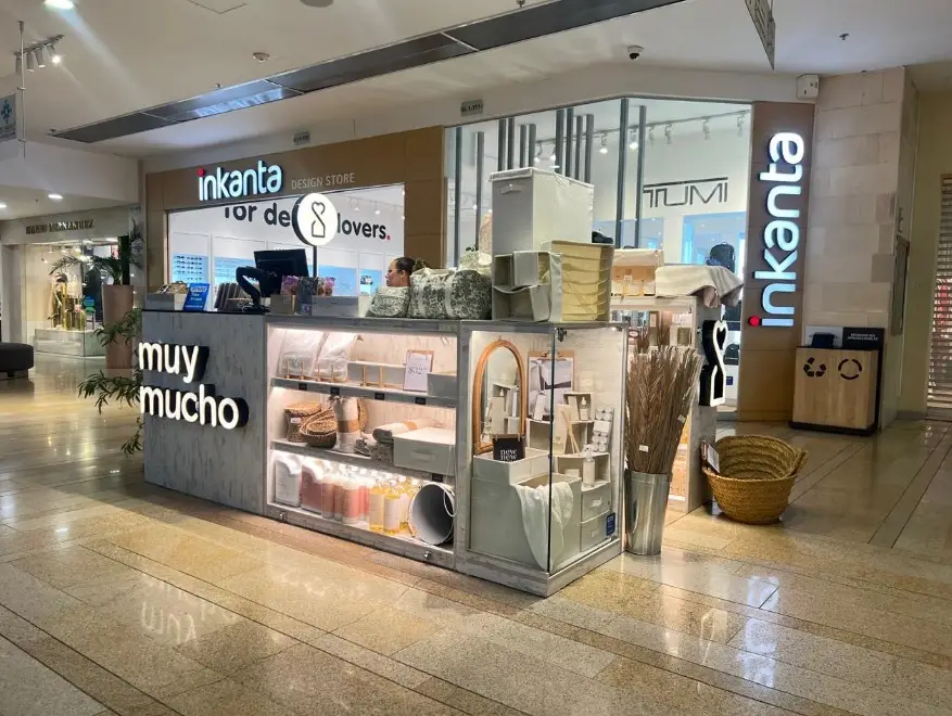 Mall kiosk named Inkanta selling home decor items such as cushions, baskets, and lamps.